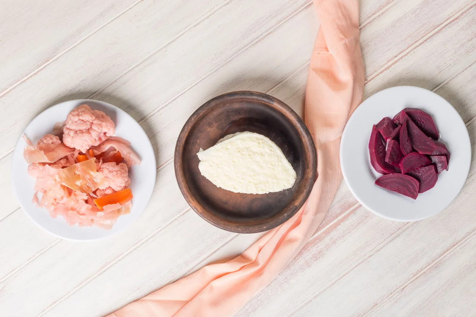 A flat lay of traditional Turkish meze plates featuring pickled vegetables and cheese.